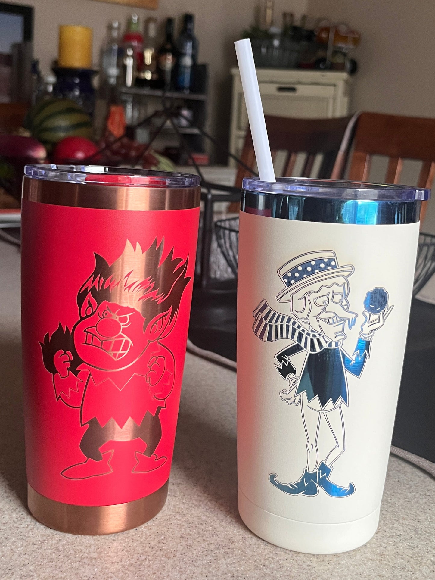 Two cylindrical containers with designs on a surface, one red and one white with blue accents.